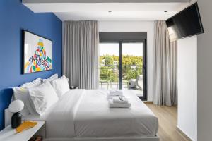 a bedroom with a white bed with a blue wall at Fits Living in Athens