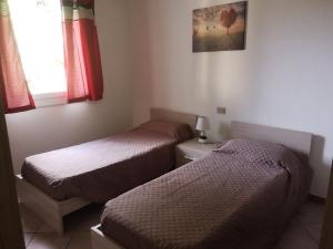 a bedroom with two beds and a window at Alloggio Residence Sa Tanca in Valledoria