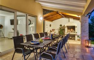 une salle à manger avec une table et des chaises et une cheminée dans l'établissement Amazing Home In Naselje Muzini, à Tomišići 20 autres photos
