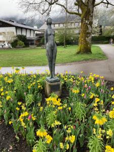 a statue of a woman in a field of flowers at Alpenrose komfortable Ferienresidenz in Oberstdorf
