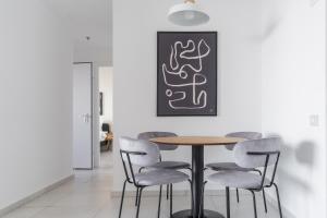 a dining room with a table and chairs at Blueground at Tzameret, Spacious, Balcony in Tel Aviv