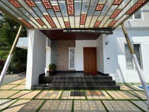 a pergola over the front door of a house at Casa Blu Villa and Event Space in Palakkad