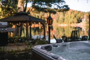 a hot tub in a yard with a gazebo at Le Cozy de St-Come - Lake front- boats in Saint Come
