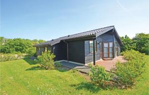 a small blue house with a deck in a field at Holiday Home Hellesvej Vestervig Denm in Vestervig