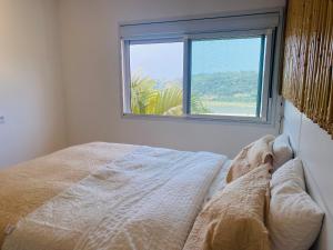 a bedroom with a bed and a window at Villa A with Sea View in Garopaba