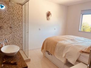 a bathroom with a bed and a shower and a sink at Villa A with Sea View in Garopaba +13 photos