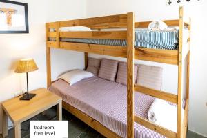a bunk bed in a room with a table at Maison a la Plage in Faros