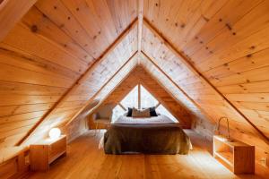 a bedroom in a wooden attic with a bed in it at Zazz - For precious moments with family or friends in Chertsey