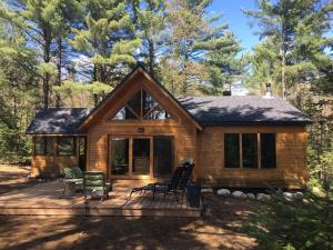 a log cabin with a deck in the woods at Zazz - For precious moments with family or friends in Chertsey