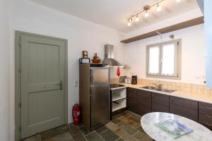 a kitchen with a refrigerator and a table in it at Maison a la Plage in Faros +22 photos