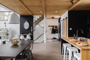 a kitchen with black and white walls and wooden ceilings at Nomade A unique experience in the heart of nature in Grande Vallee