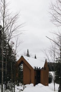 a wooden building with snow on top of it at Nomade A unique experience in the heart of nature in Grande Vallee