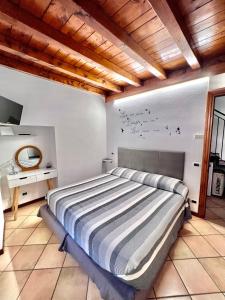 a bedroom with a large bed and a wooden ceiling at Vittoria Holiday House Stresa in Stresa