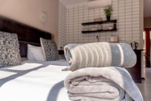 a pile of towels sitting on top of a bed at Easy overnight in Bloemfontein in Bloemfontein