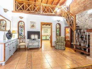 ein großes Wohnzimmer mit Fernseher und Treppe in der Unterkunft Villa Verde in Nigüelas