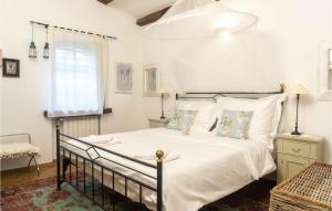 a bedroom with a bed with white sheets and pillows at Villa Montona in Višnjan