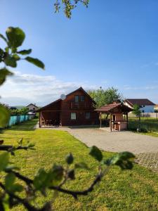 a large wooden building with a pavilion in a yard at Cabana Kris in Orlat