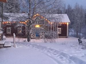 KorvalaにあるKorvala log cabinsの雪に覆われた家