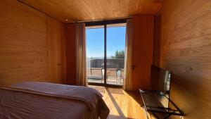 ein Schlafzimmer mit einem Bett, einem Fernseher und einem Fenster in der Unterkunft Casa Morro Punta de Lobos in Pichilemu