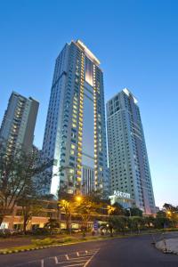 three tall buildings in a city at night at Ascott Waterplace Surabaya in Surabaya