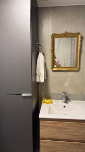 a bathroom with a sink and a mirror and a refrigerator at Fit 26 26 de marzo 3330 in Montevideo