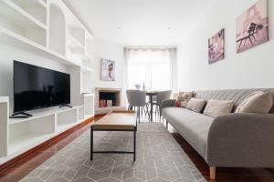 a living room with a couch and a flat screen tv at Suite Deluxe By Princesa con Parking in Vigo