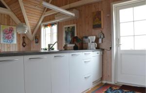 a kitchen with white cabinets and a white door at Holiday Home Fanø 24 in Fanø
