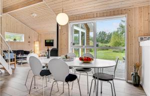 a kitchen and dining room with a table and chairs at Cozy Home In Ålbæk With Kitchen in Ålbæk