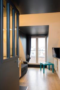 Sala de estar con puerta, sofá y mesa en Little Suite - Marius et Romain, en Lille