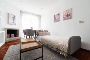 a living room with a bed and a table and a couch at Suite Deluxe By Princesa con Parking in Vigo