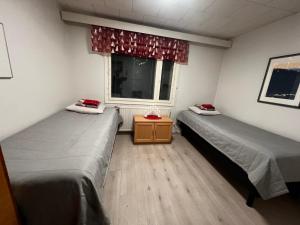 two beds in a room with a window at Villa Narikka, Tilava ja rauhallinen loma-asunto Kittilän keskustassa in Kittilä