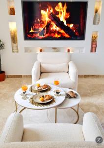 un soggiorno con camino e tavolo con cibo sopra di - LA SUITE DELOS - JACUZZI 2 PLACES - CENTRE VILLE A PIED - LIT QUEEN SIZE - PARKING PRIVÉE - WIFI - City Center within walking distance - a Quimper