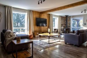 ein Wohnzimmer mit Sofa und Fernseher in der Unterkunft Entre Monts et Lac - lac - Lake front & Volleyball in Saint Adolphe D'Howard + 35 Fotos