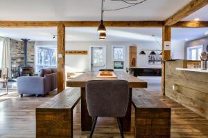 a kitchen and living room with a wooden table and chairs at Entre Monts et Lac - lac - Lake front & Volleyball in Saint Adolphe D'Howard +35 photos