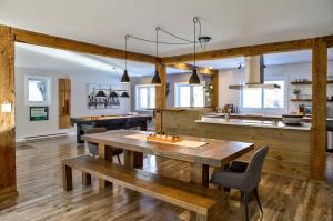 a kitchen with a wooden table and a dining room at Entre Monts et Lac - lac - Lake front & Volleyball in Saint Adolphe D'Howard