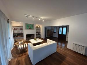 ein Wohnzimmer mit einer weißen Couch und einem Tisch in der Unterkunft Praderas de San Lorenzo in El Durazno