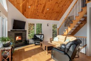 a living room with a couch and a fireplace at Le Plein Sud - Your ideal getaway by Lake Lise in Chertsey