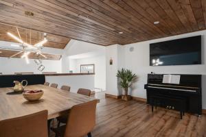 ein Esszimmer mit einem Tisch und einem Klavier in der Unterkunft O Sommet -Game room-Spa-sauna-Lake Access in Chertsey