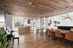 ein Esszimmer und eine Küche mit Holzdecke in der Unterkunft O Sommet -Game room-Spa-sauna-Lake Access in Chertsey