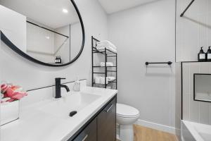a white bathroom with a sink and a mirror at Flora's House in Calgary