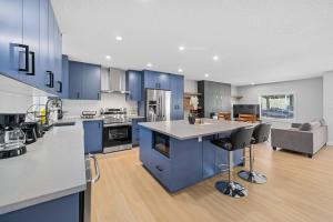 a large kitchen with blue cabinets and a kitchen island at Flora's House in Calgary