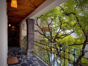 a porch of a house with a fence and a tree at Hotel Boutique Casa Laja in San Miguel de Allende