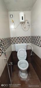 a bathroom with a white toilet in a room at Shree chendur Residency tvm in Tiruvannāmalai