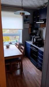 a kitchen with a table and a kitchen with blue cabinets at Briedis un partneri in Cēsis