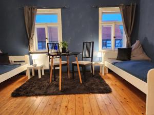 a room with two beds and a table and chairs at Schwalbenhof in Lommatzsch