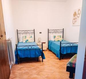 a bedroom with two beds with blue sheets at Casa Silvia Balsorano in Balsorano Vecchio