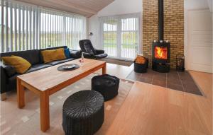 a living room with a couch and a fireplace at Holiday Home Pilemose in Skovby