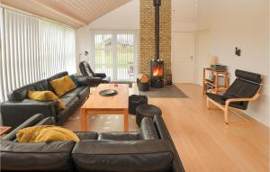 a living room with a black couch and a table at Holiday Home Pilemose in Skovby