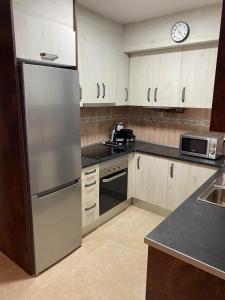 a kitchen with a refrigerator and a microwave at Apartamento Pilarín in Alcañiz