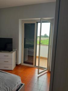 a bedroom with a sliding glass door to a balcony at domum solis in Marina di Cerveteri